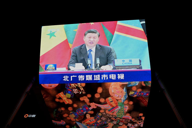 China's President Xi Jinping is pictured on a big screen during an evening news program, showing Xi's keynote speech at the opening ceremony of the 8th Forum on China-Africa Cooperation (FOCAC) at a mall in Beijing on November 30, 2021. (Photo by Noel Celis / AFP)